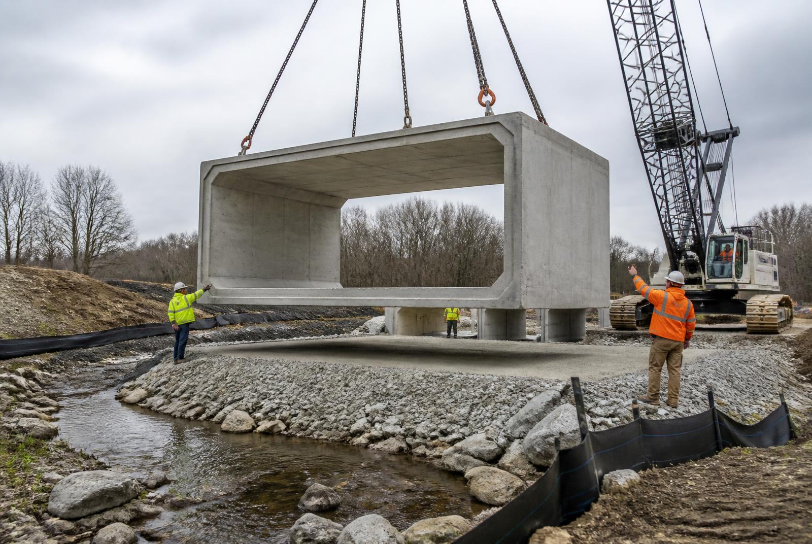 Crane setting a precast concrete culvert structure into place on an Ontario municipal civil works site